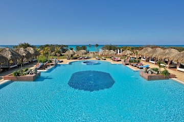 a pool with umbrellas and chairs and a beach