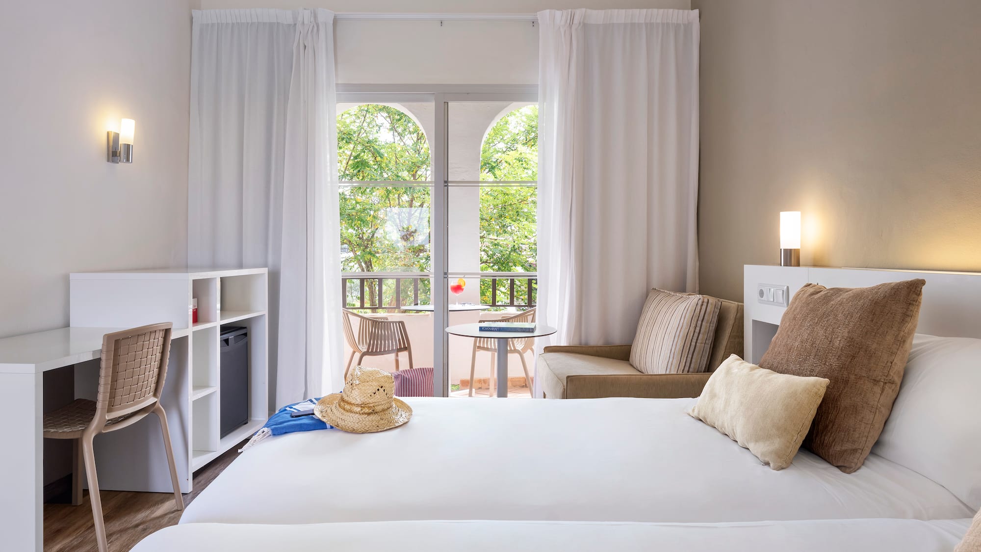 a room with two beds and a chair and a table