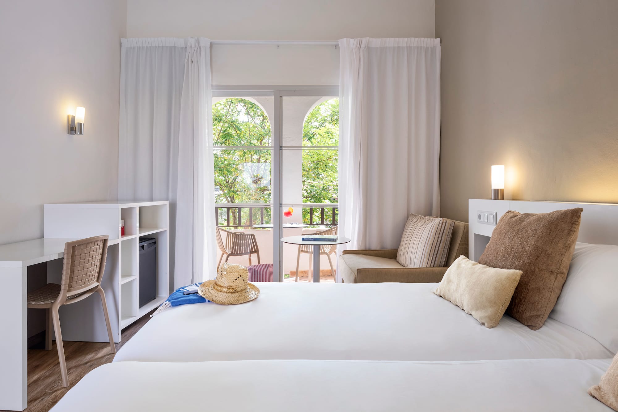 a room with two beds and a chair and a table