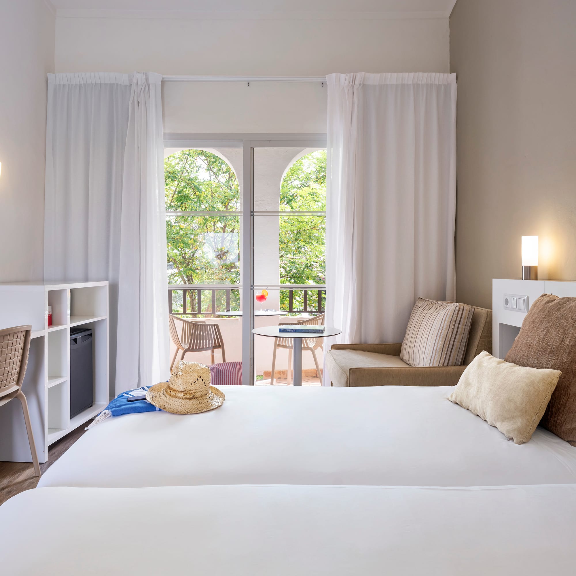 a room with two beds and a chair and a table