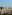 Vista panorámica de Barcelona con Sagrada Familia, edificios y montañas al atardecer.