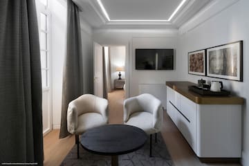 a room with white furniture and a black table