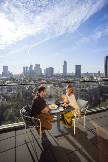 a man and woman sitting at a table with food on it
