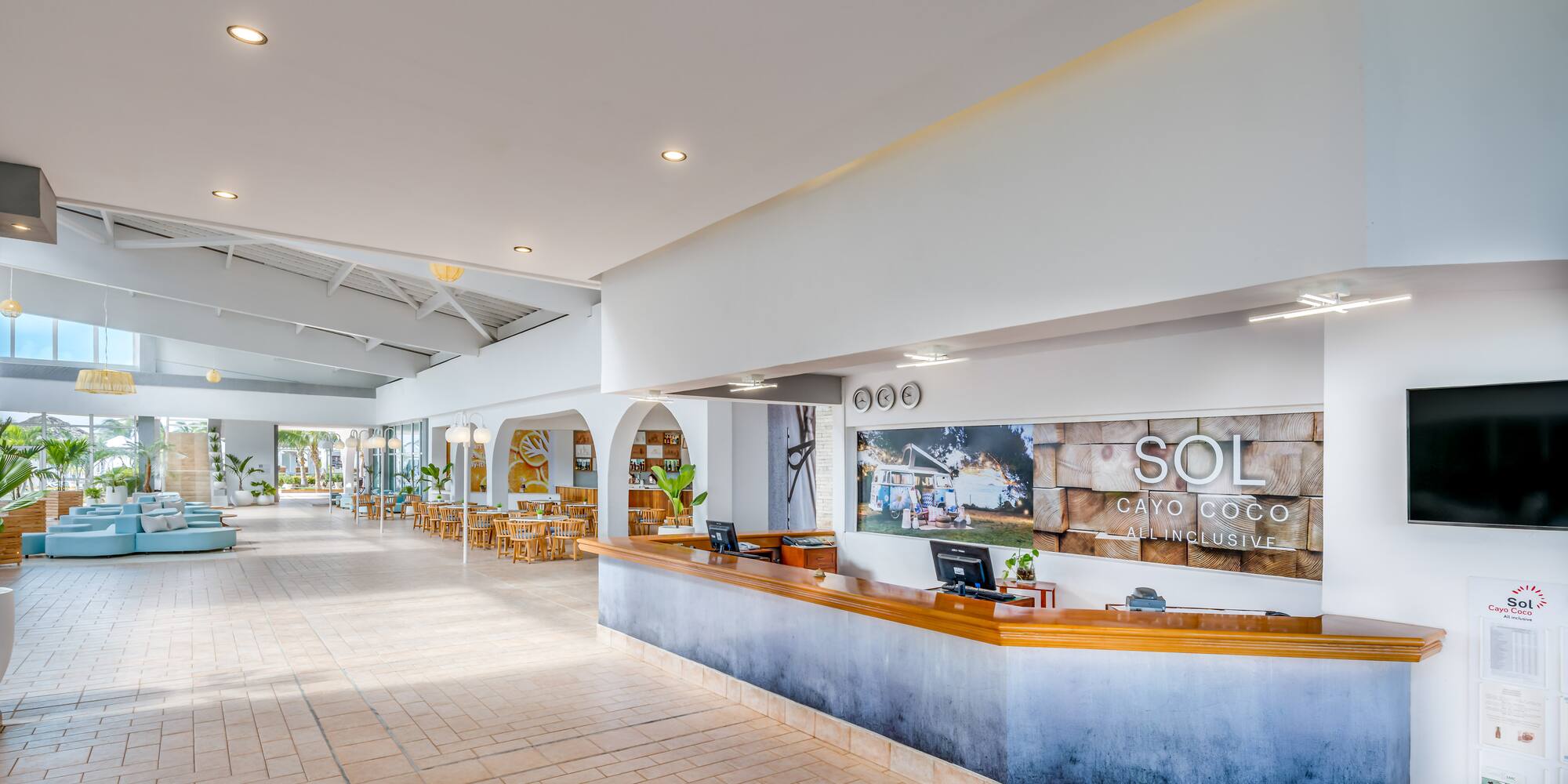 a lobby with a reception desk and tables