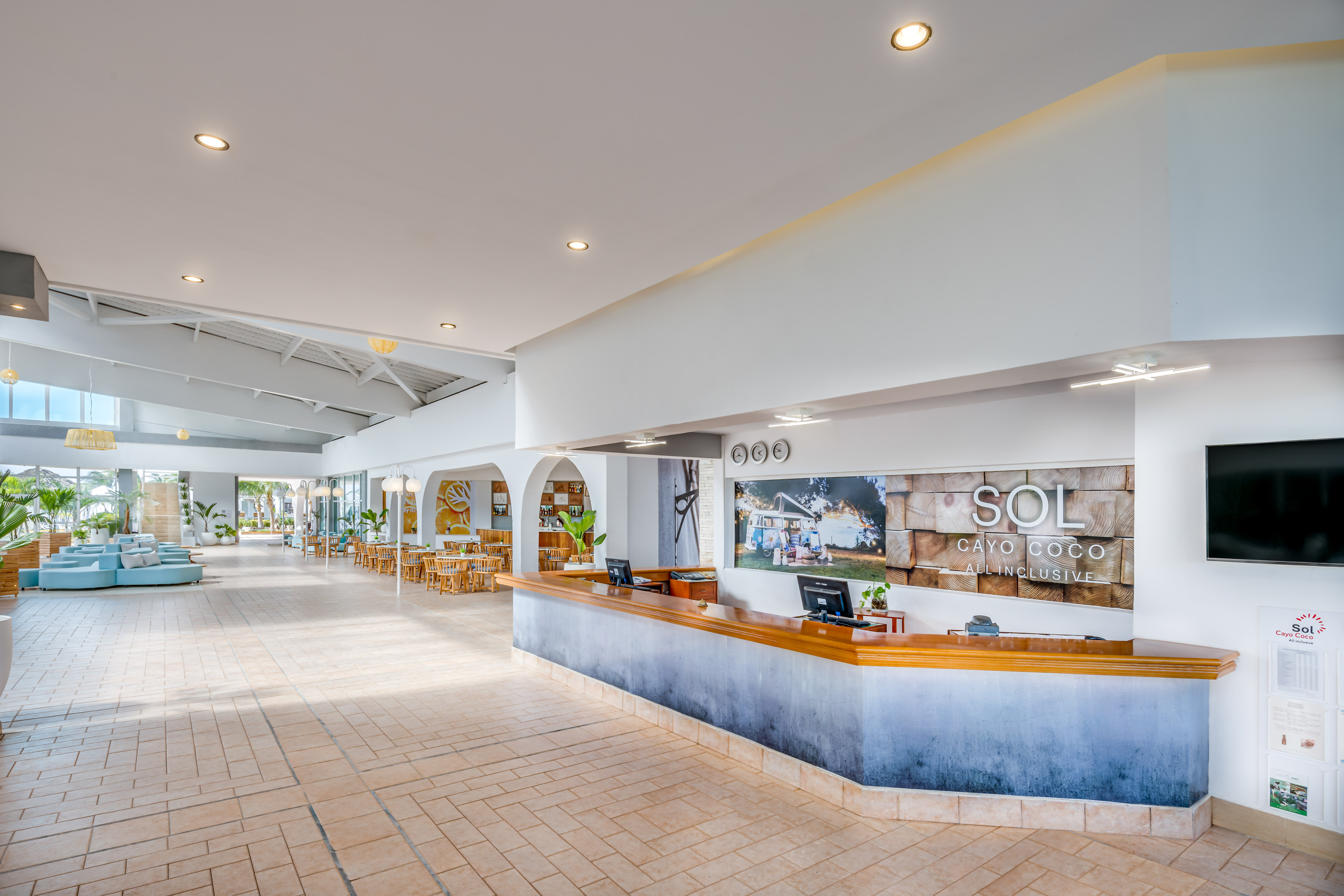 a lobby with a reception desk and tables