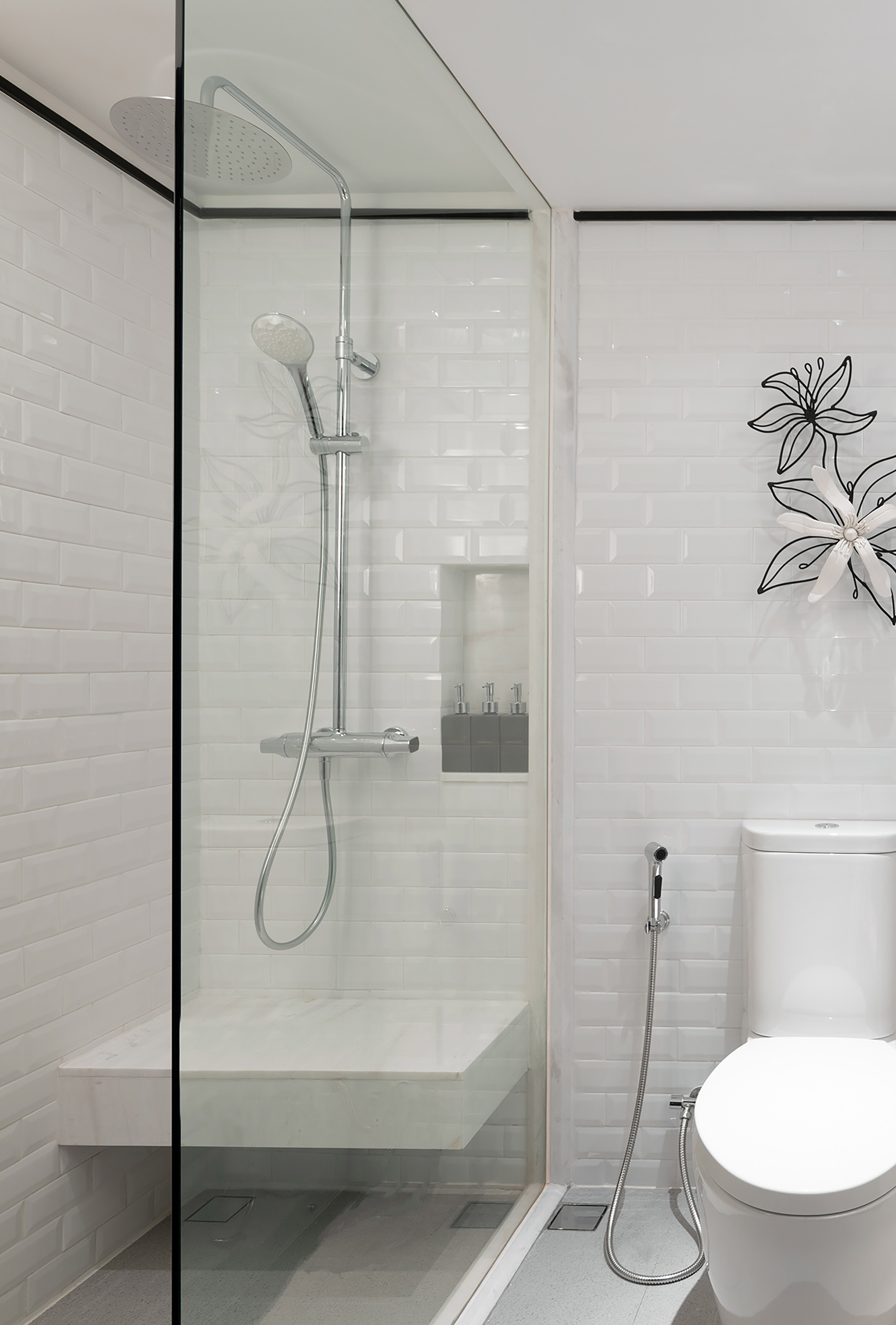 Contemporary bathroom with glass shower, rain head, white subway tiles, toilet.