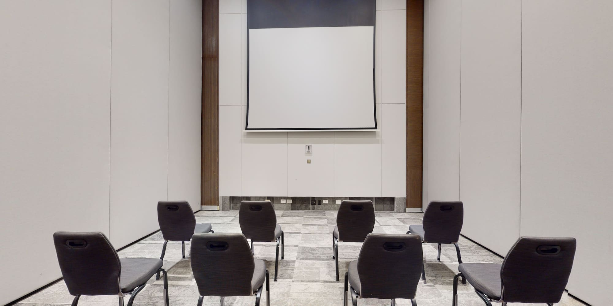 a room with chairs and a projector screen