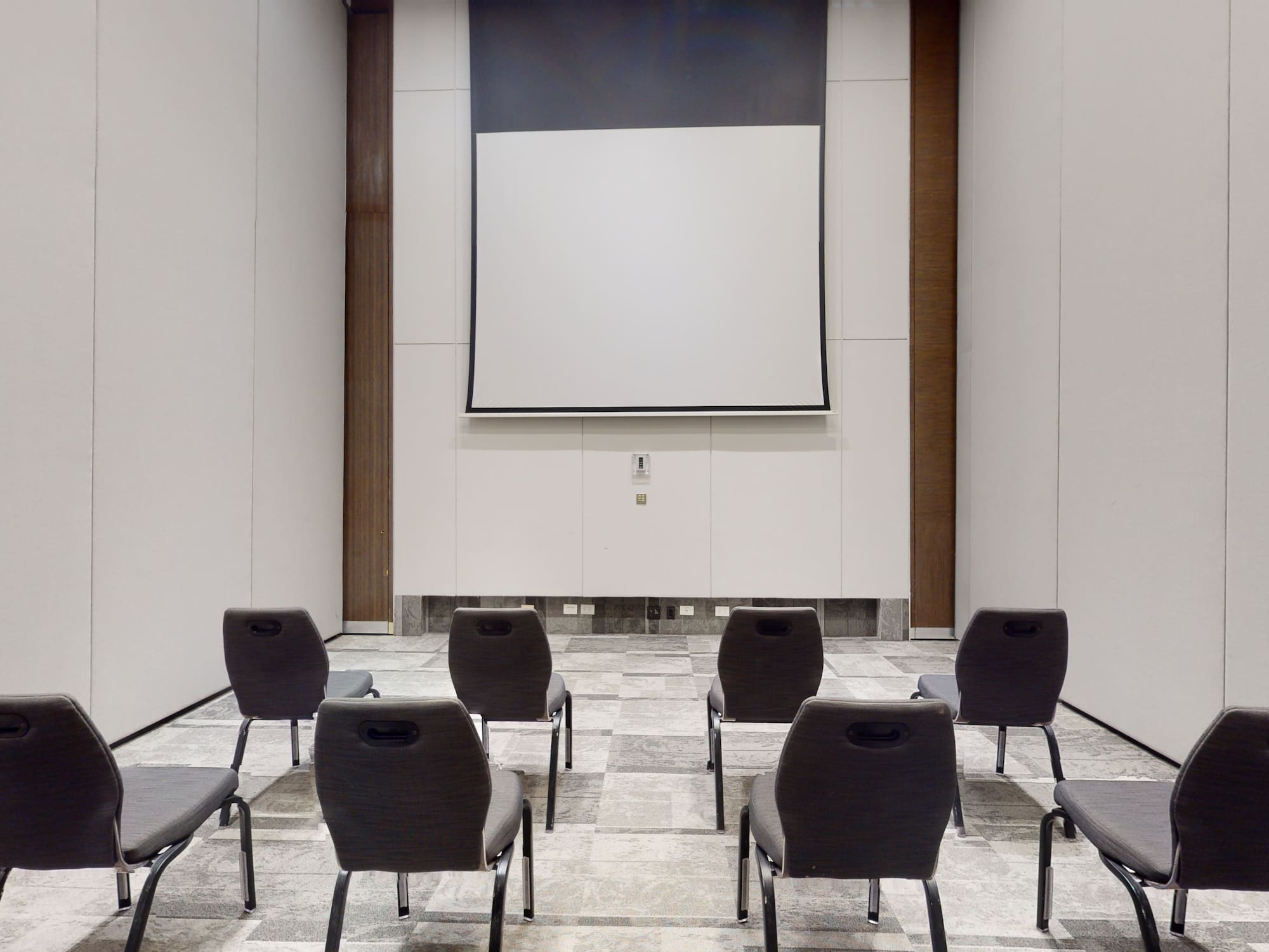 a room with chairs and a projector screen