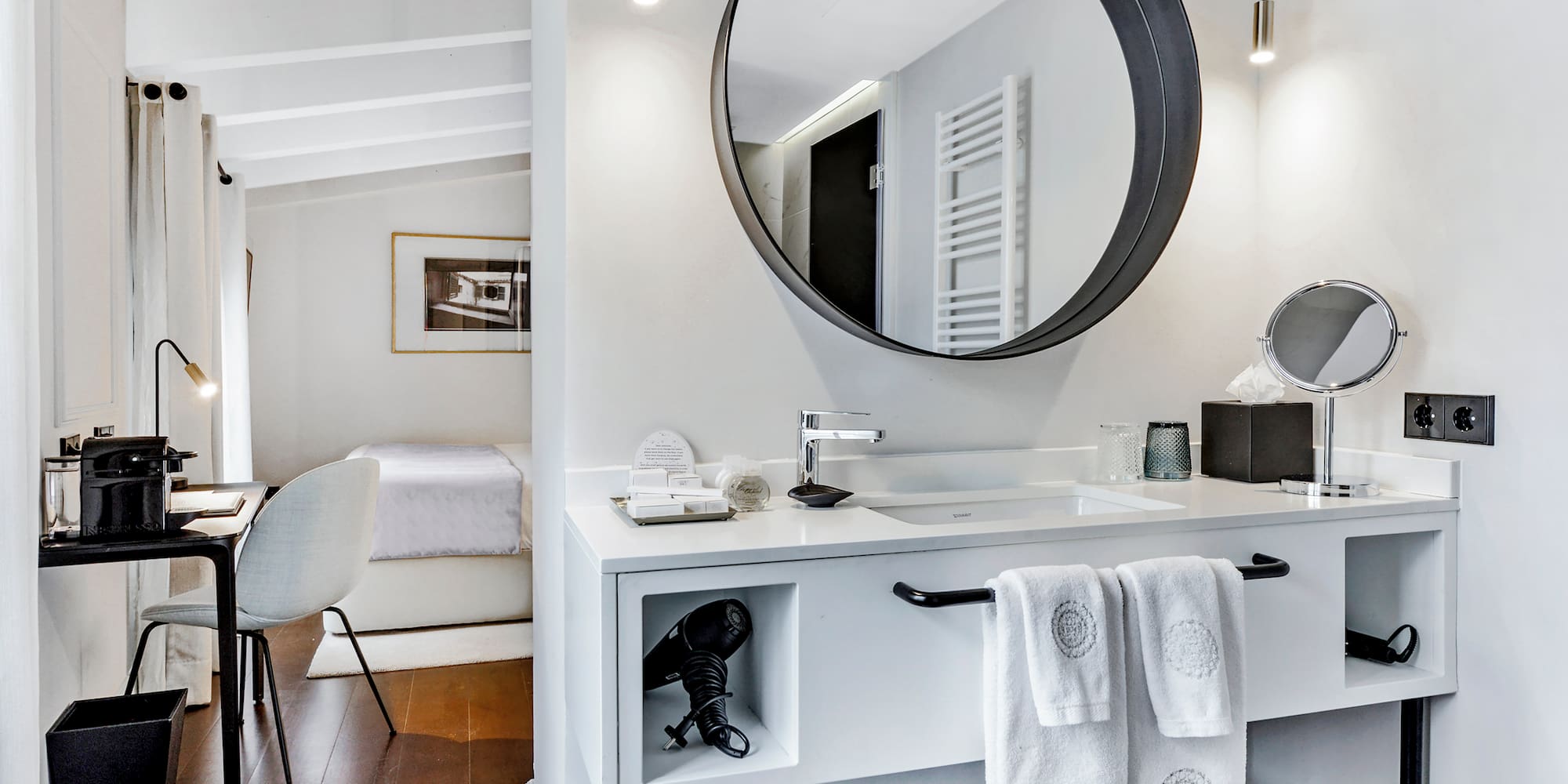 uma cama com almofadas brancas e um espelho em um quarto