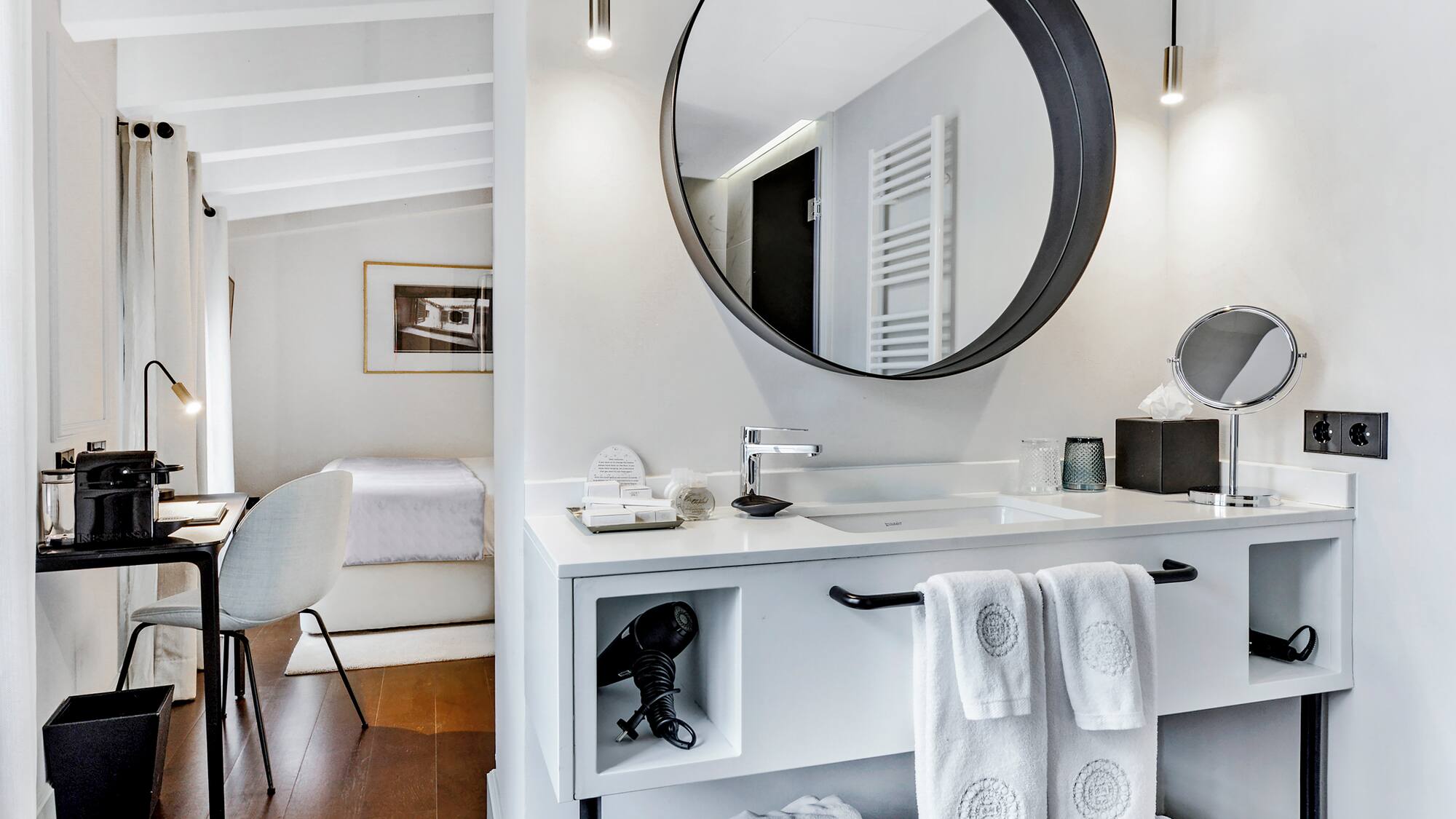 een bed met witte kussens en een spiegel in een kamer