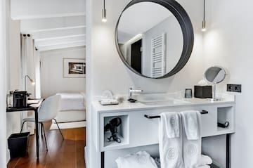 un lit avec des oreillers blancs et un miroir dans une chambre