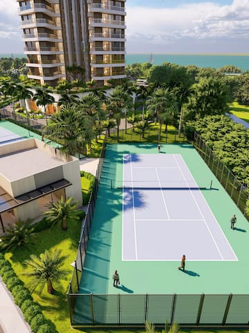 a tennis court with trees and buildings in the background