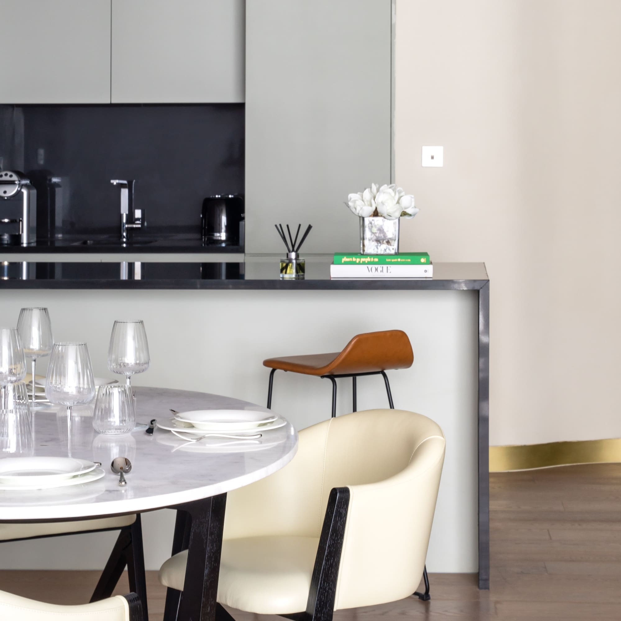 a table with white chairs and a black countertop