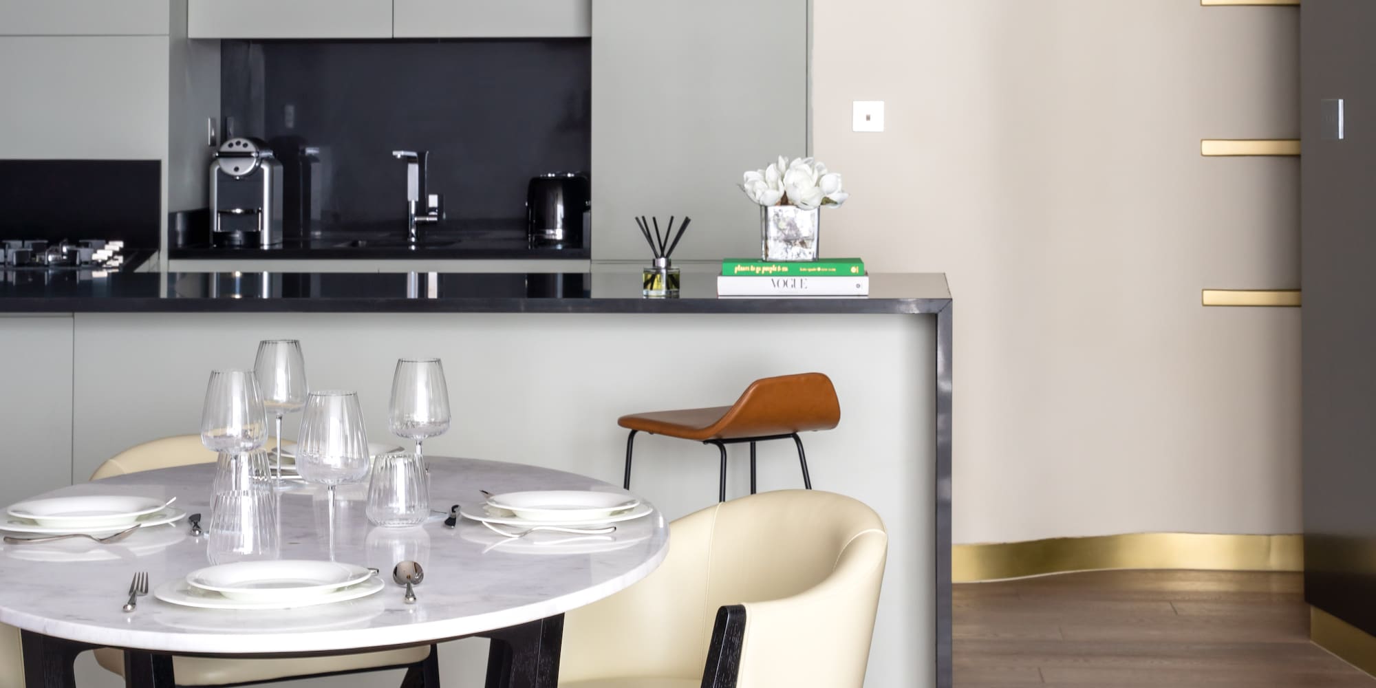 a table with white chairs and a black countertop