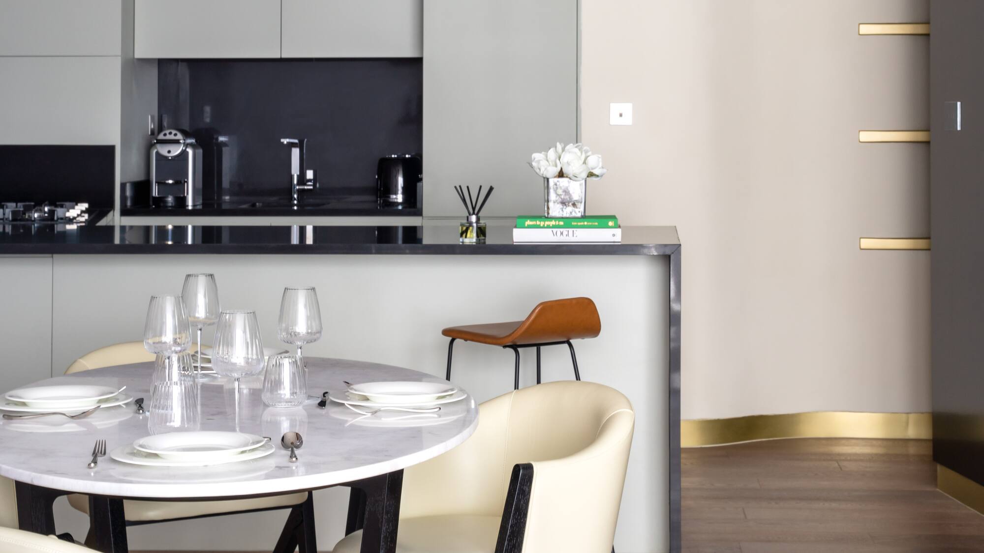 a table with white chairs and a black countertop