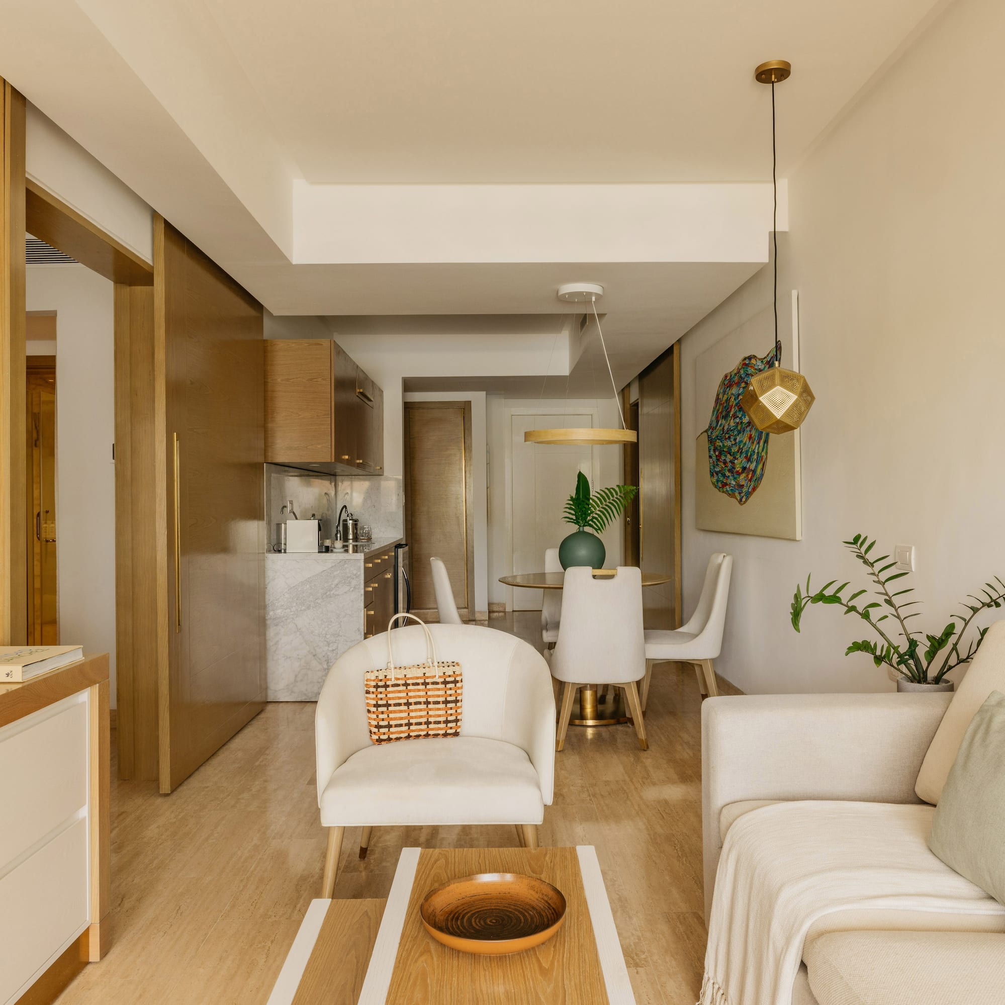 Modern open-concept living & dining room with neutral furniture, kitchen area.