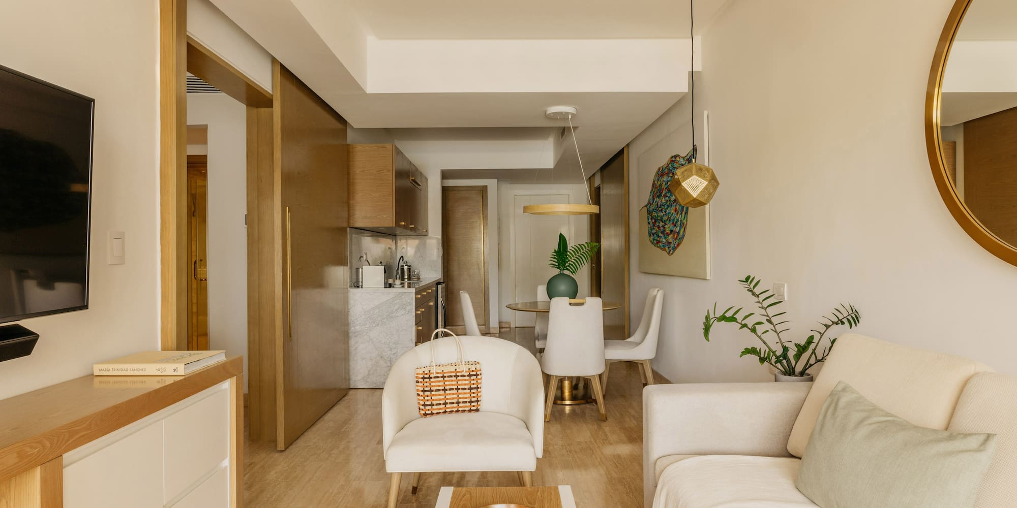 Modern open-concept living & dining room with neutral furniture, kitchen area.