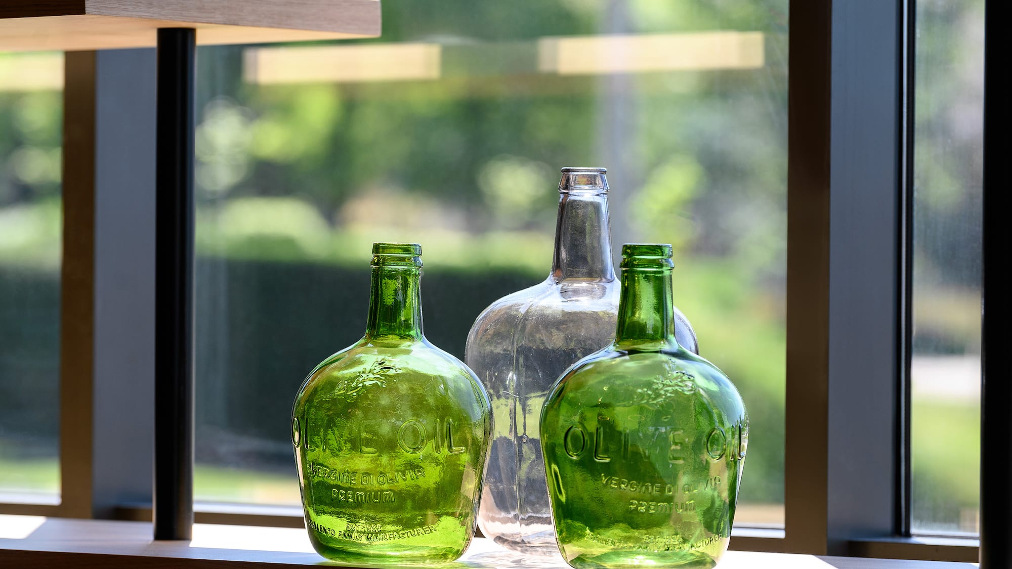 a group of green glass bottles on a window sill