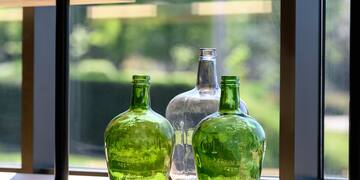 a group of green glass bottles on a window sill