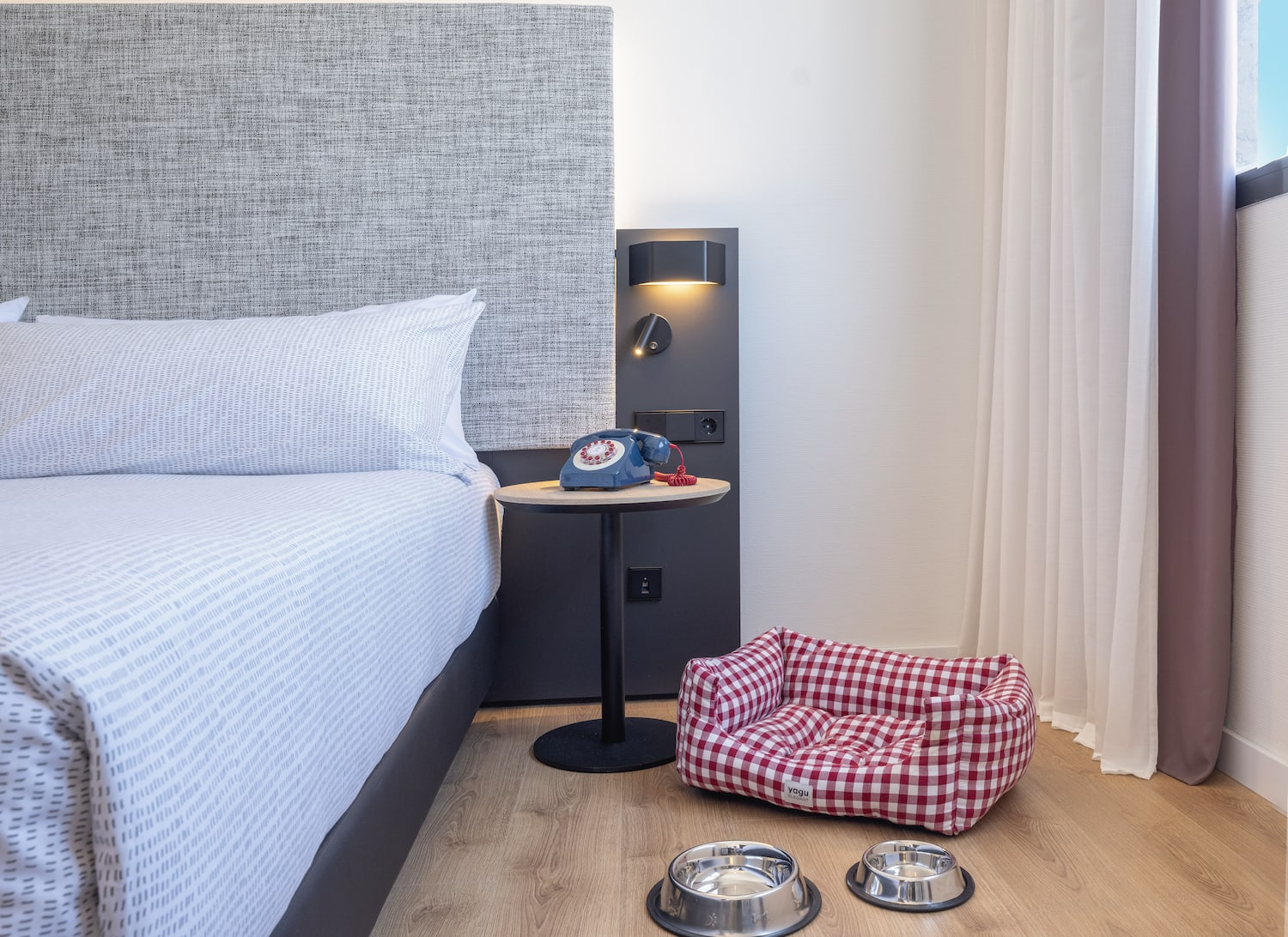 a dog bed and bowls on the floor