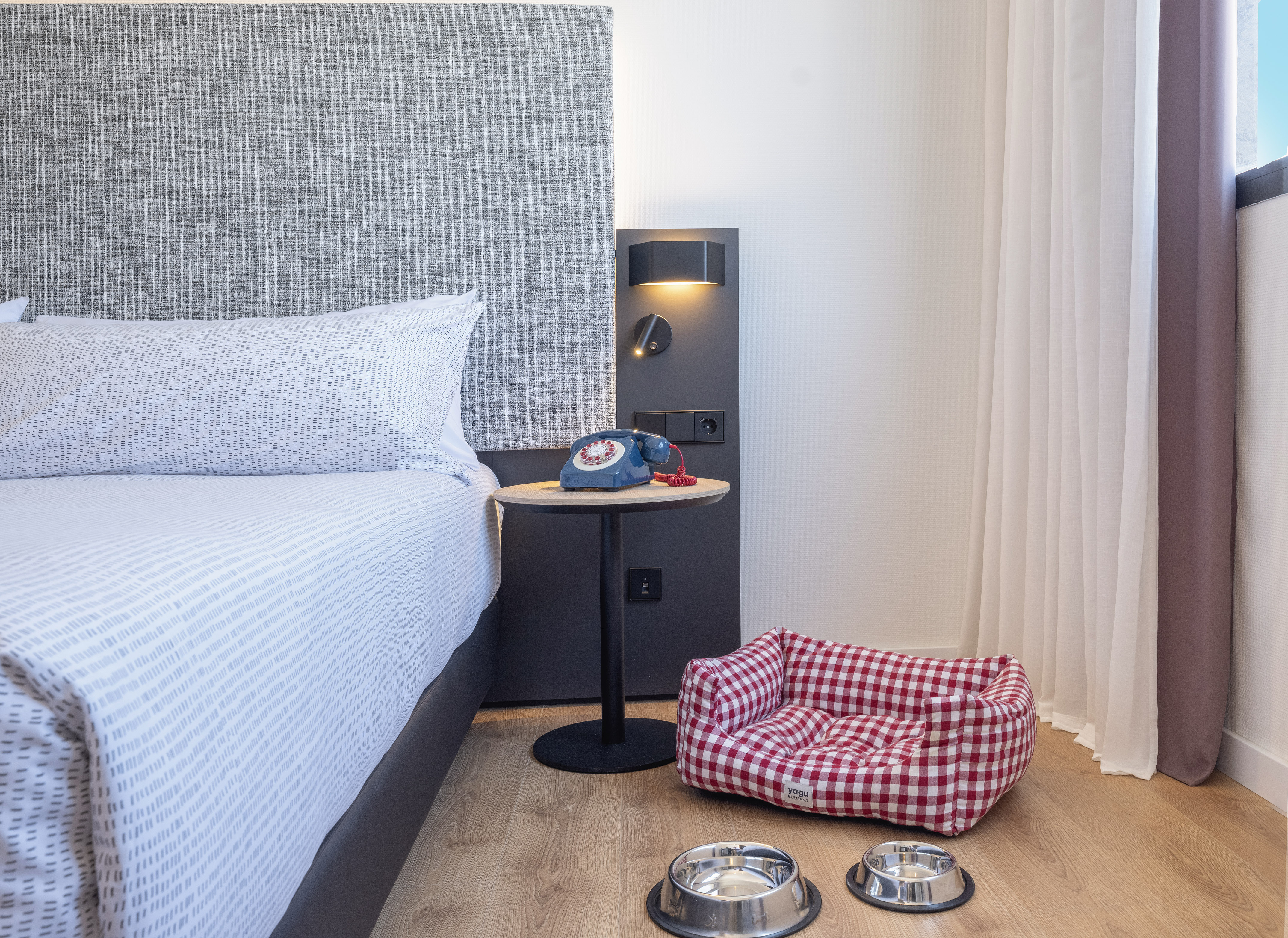 a dog bed and bowls on the floor