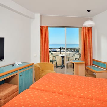 a room with two beds and a television