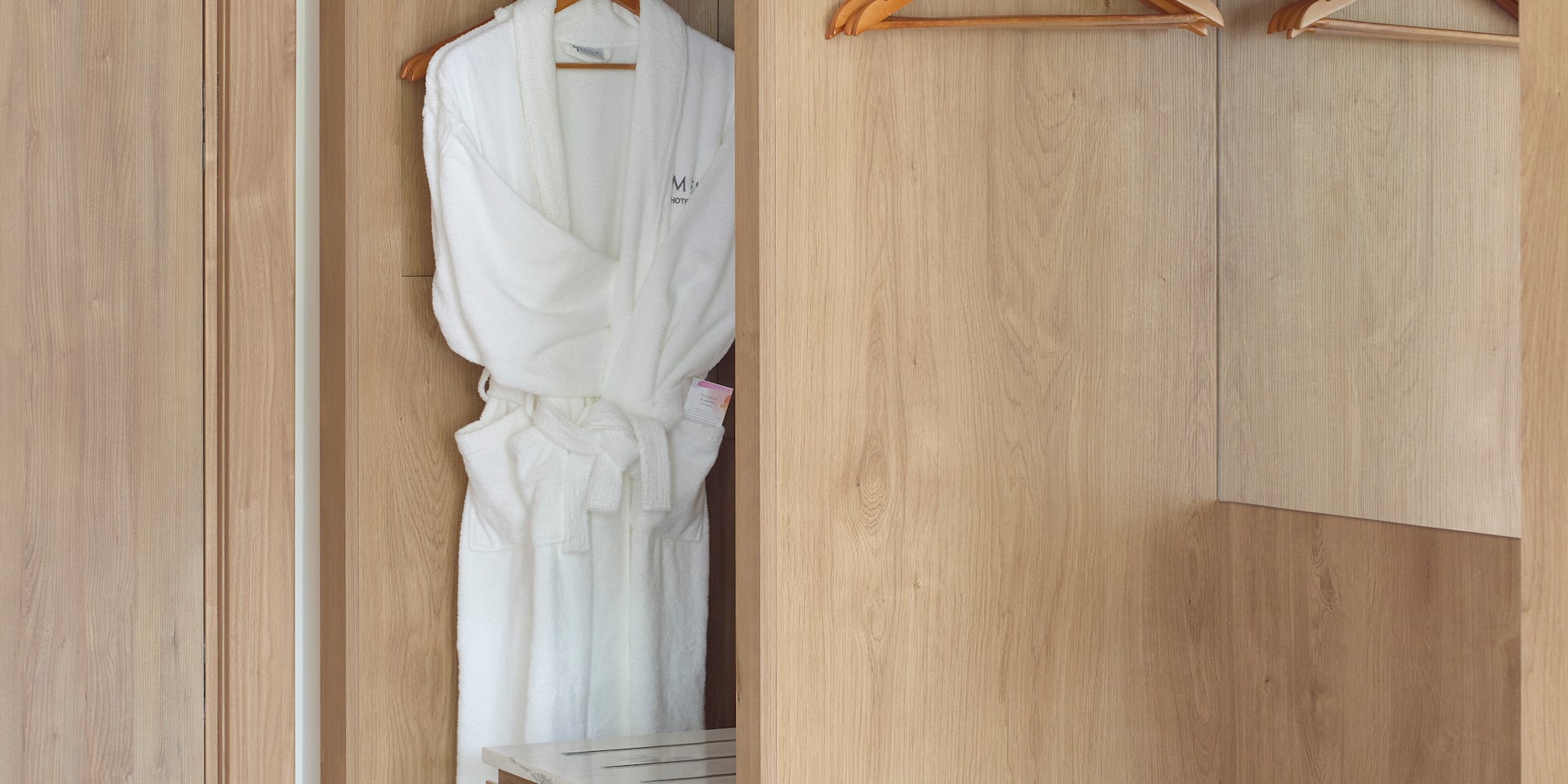 a closet with white robe and swingers
