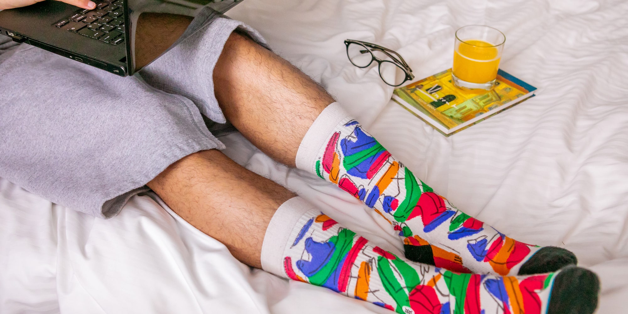 a person wearing colorful socks and holding a laptop
