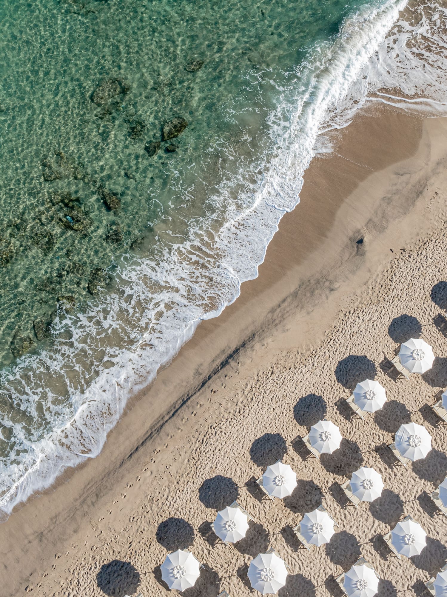 a beach with umbrellas and waves