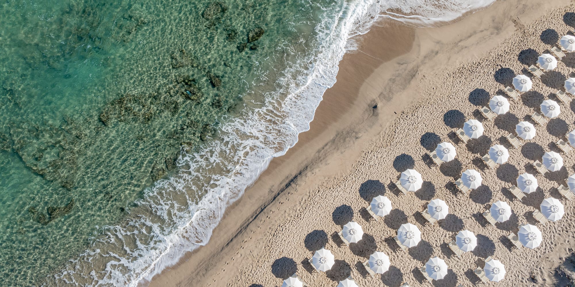 a beach with umbrellas and waves
