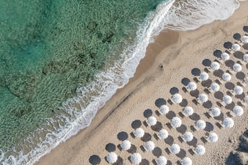 a beach with umbrellas and waves