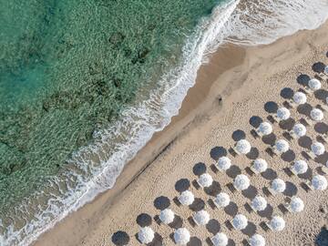 a beach with umbrellas and waves