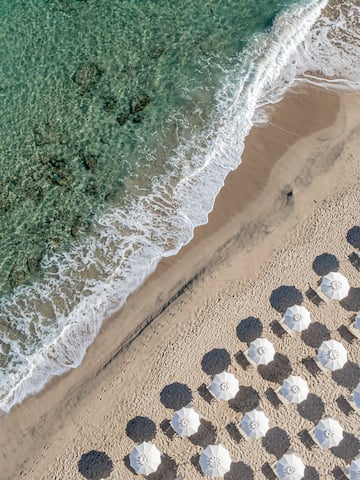 a beach with umbrellas and waves