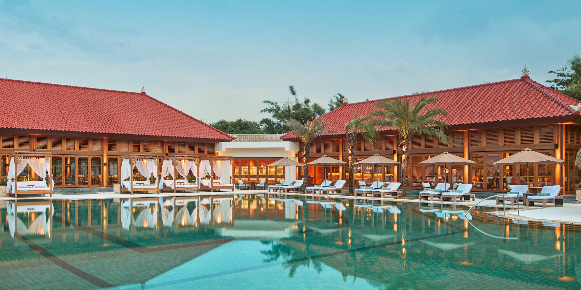 a pool with lounge chairs and palm trees