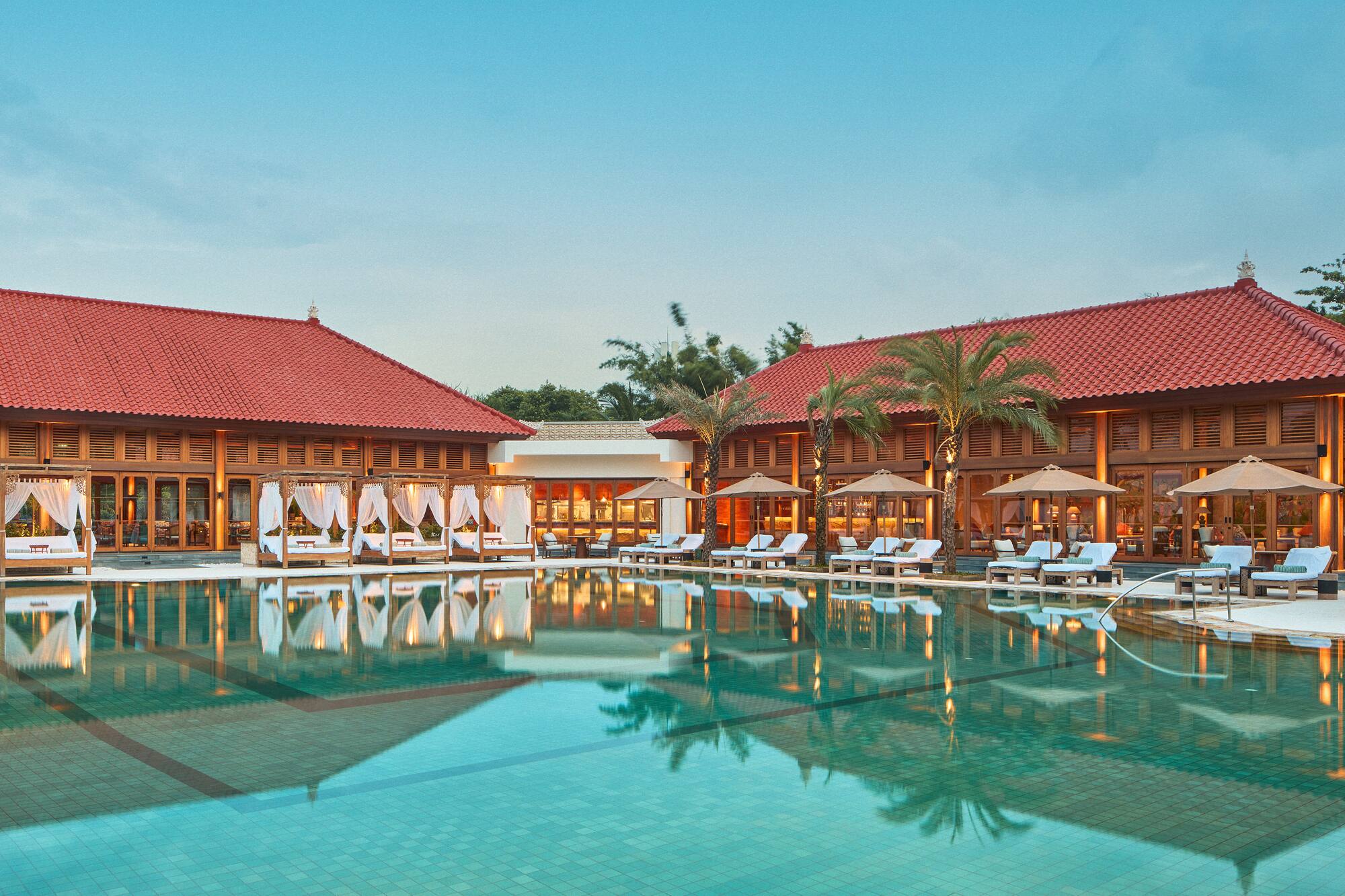 a pool with lounge chairs and palm trees