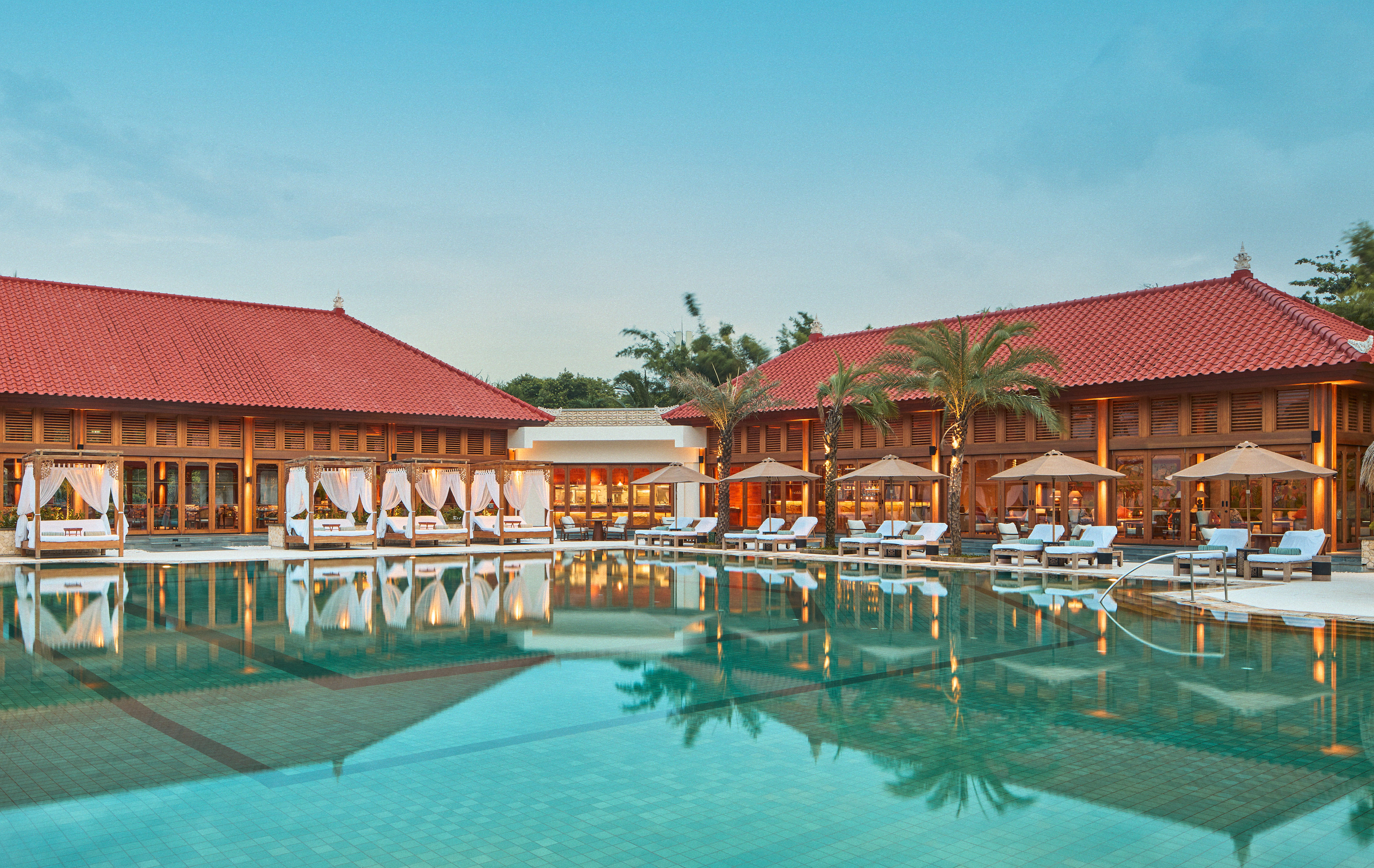 a pool with lounge chairs and palm trees