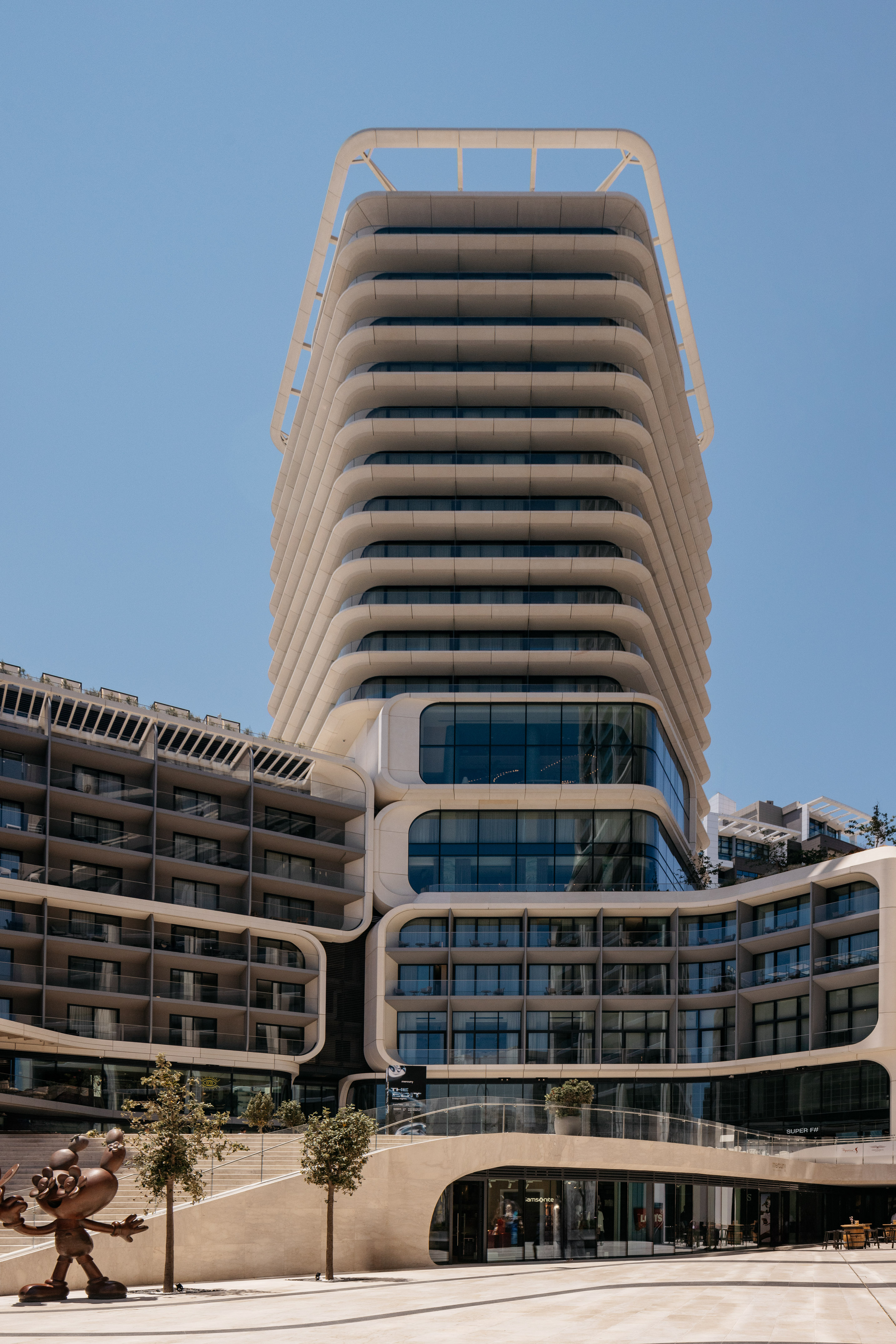 Contemporary hotel building with unique curved white balconies and glass.