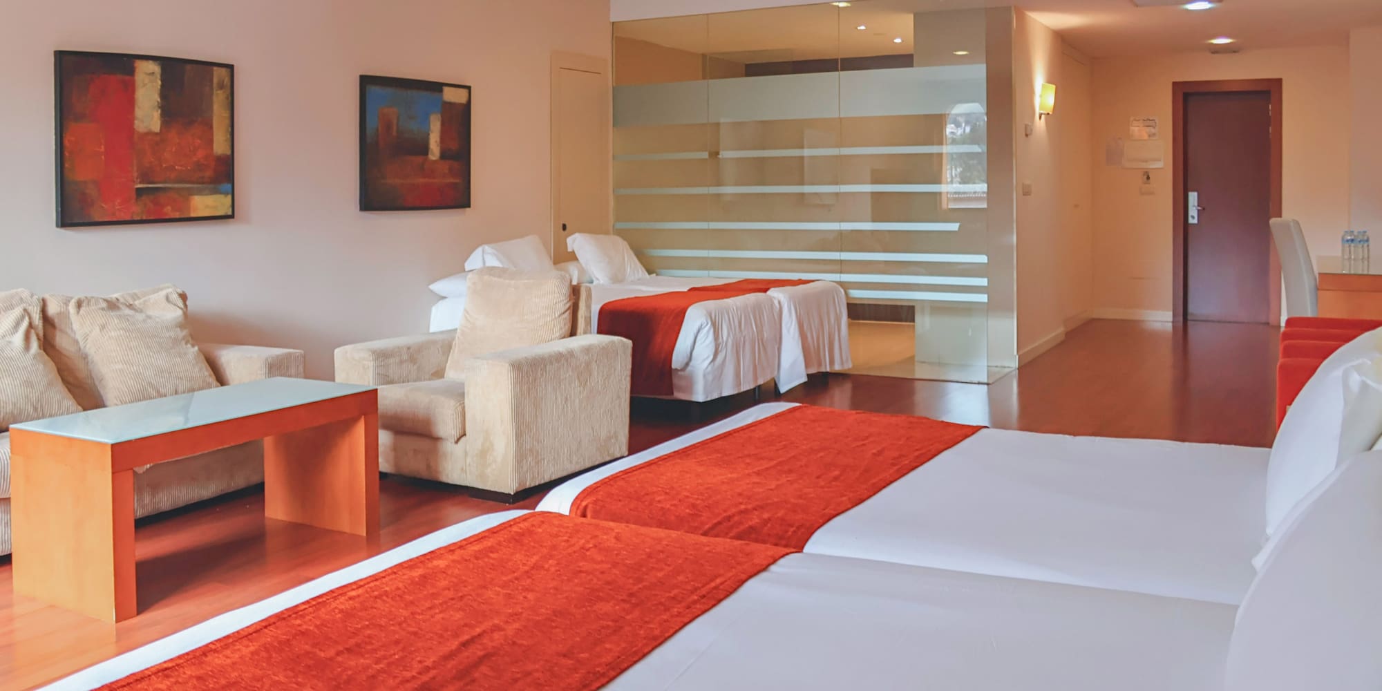 a room with two beds and a glass wall