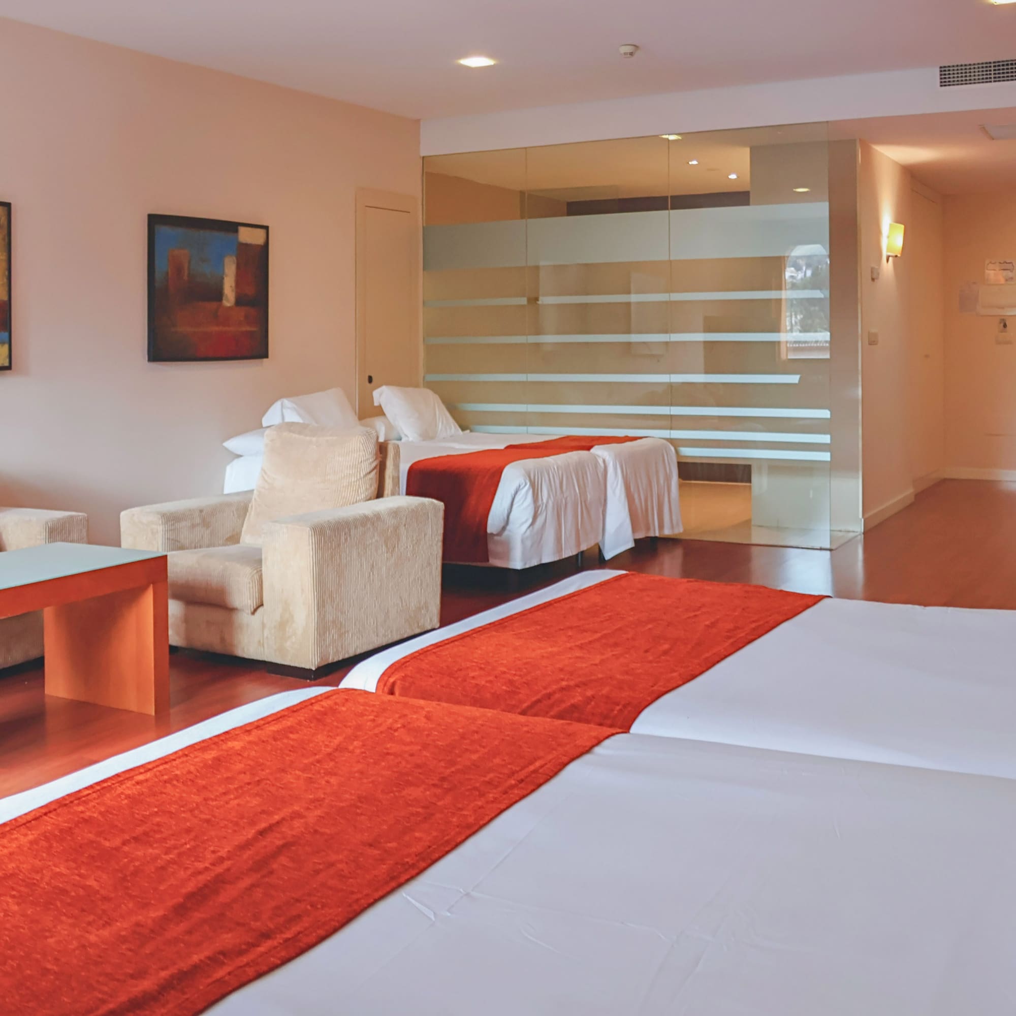 a room with two beds and a glass wall