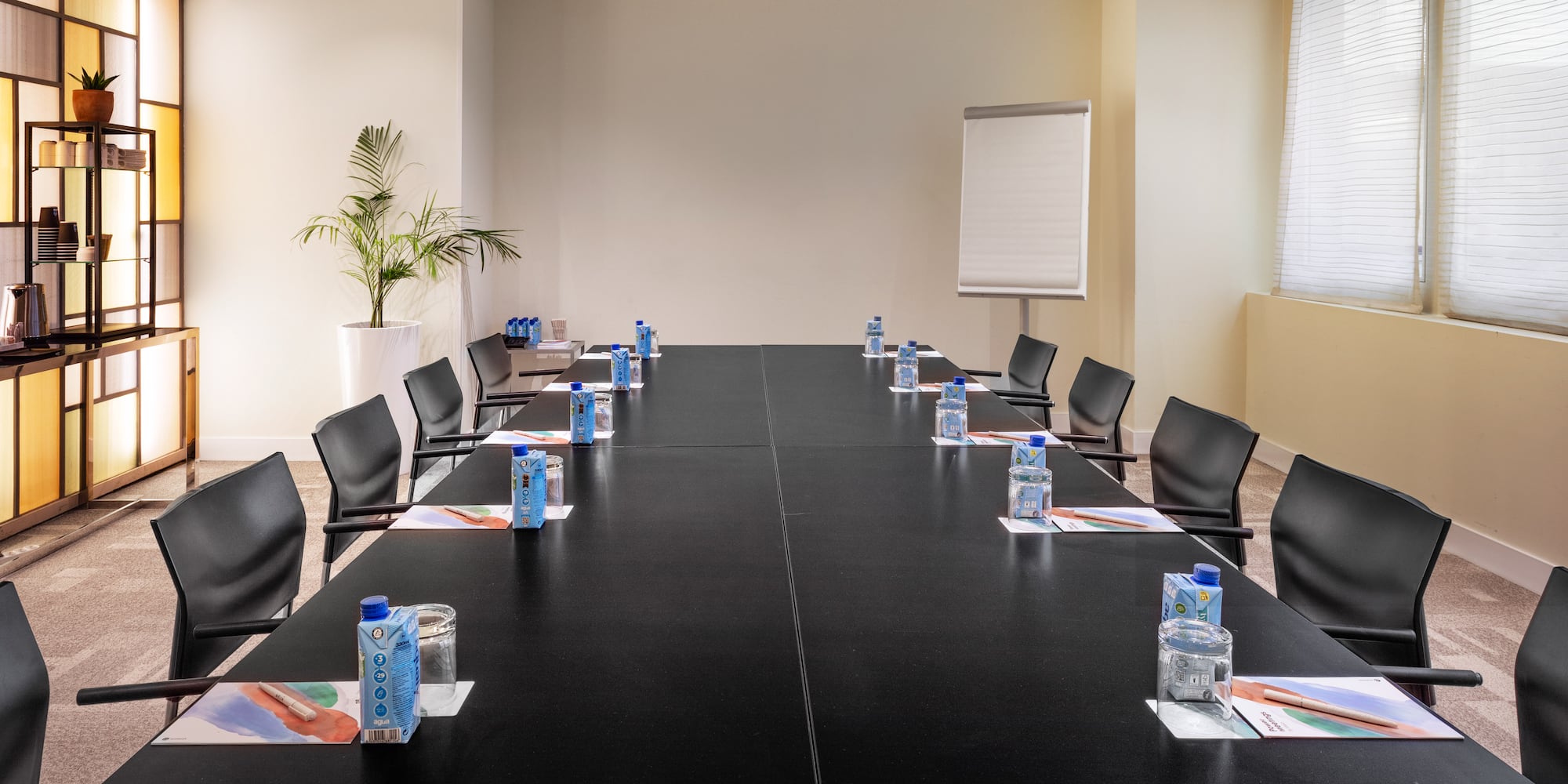 a conference room with a black table and chairs