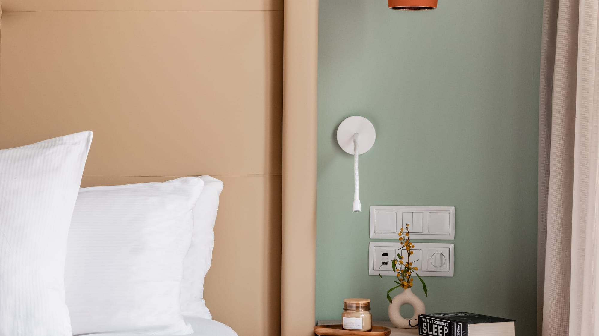 a bed with a pink blanket and a small end table