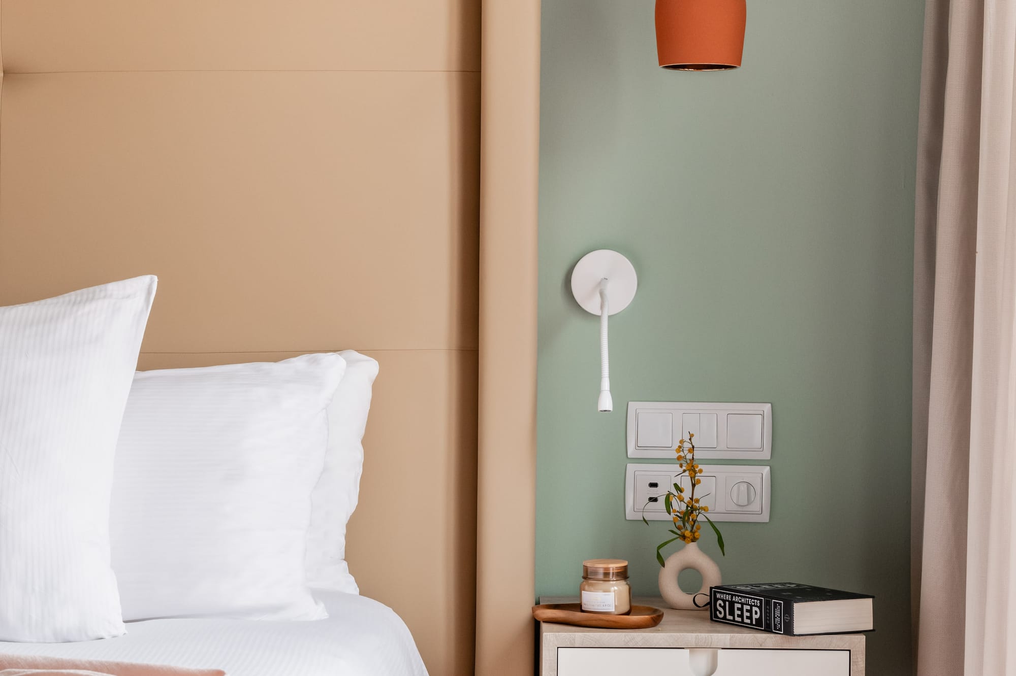 a bed with a pink blanket and a small end table