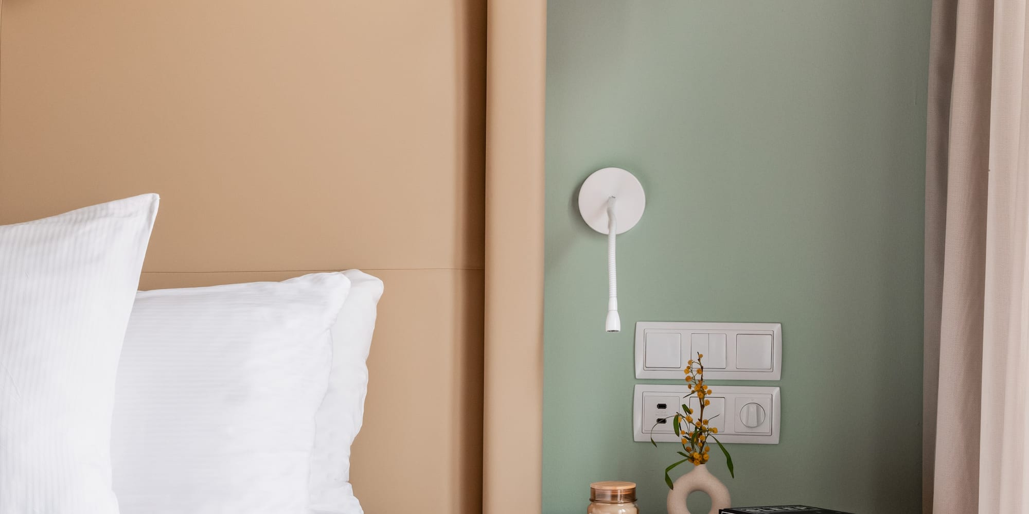 a bed with a pink blanket and a small end table