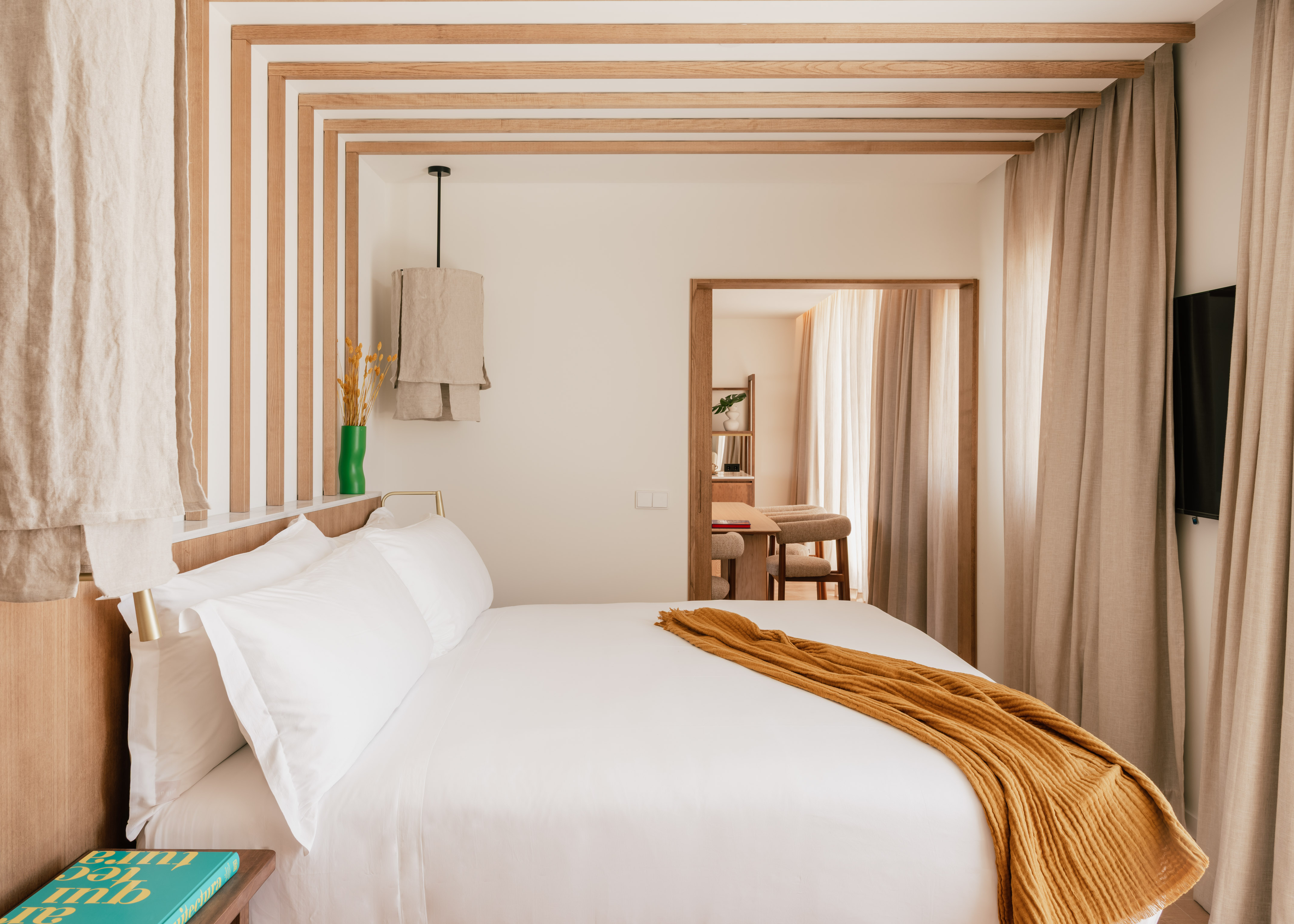 a bed with white sheets and a yellow blanket