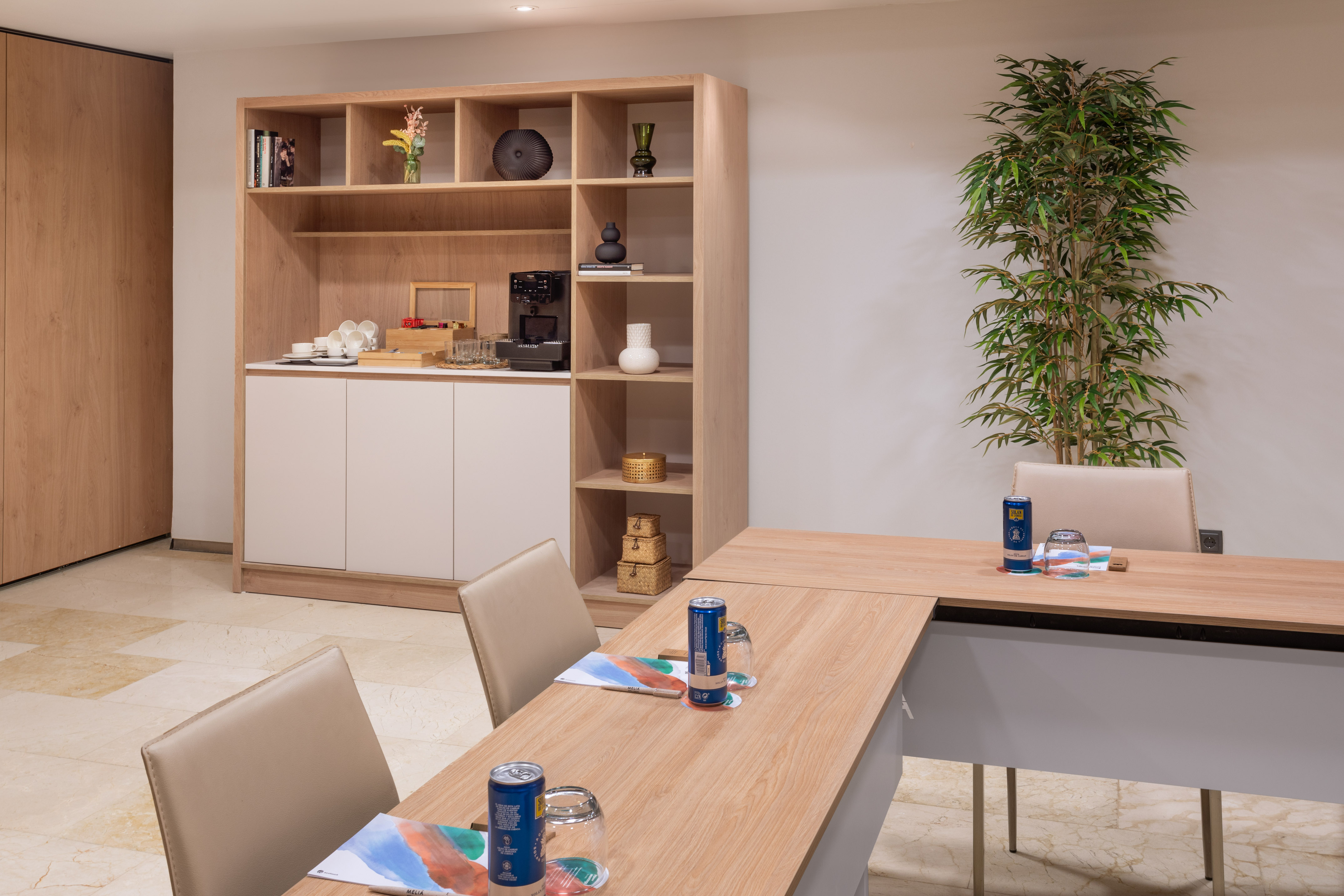Modern conference room with wood coffee station, meeting table, and chairs.