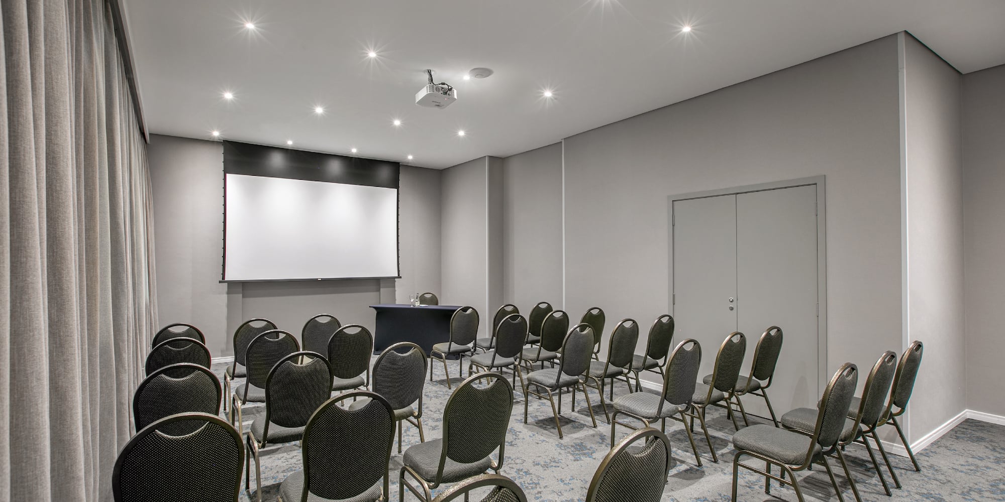 a room with chairs and a projector screen