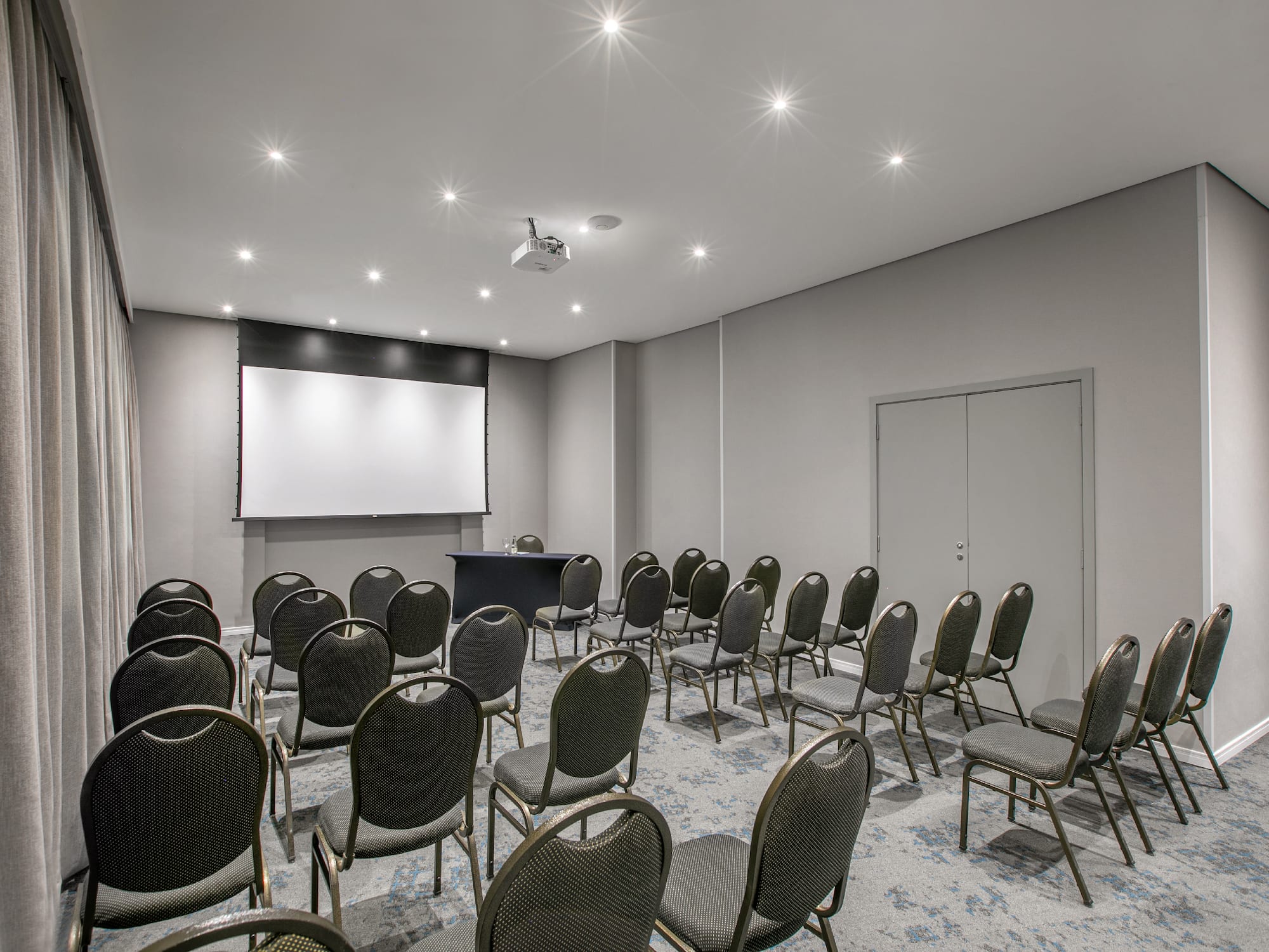 a room with chairs and a projector screen.