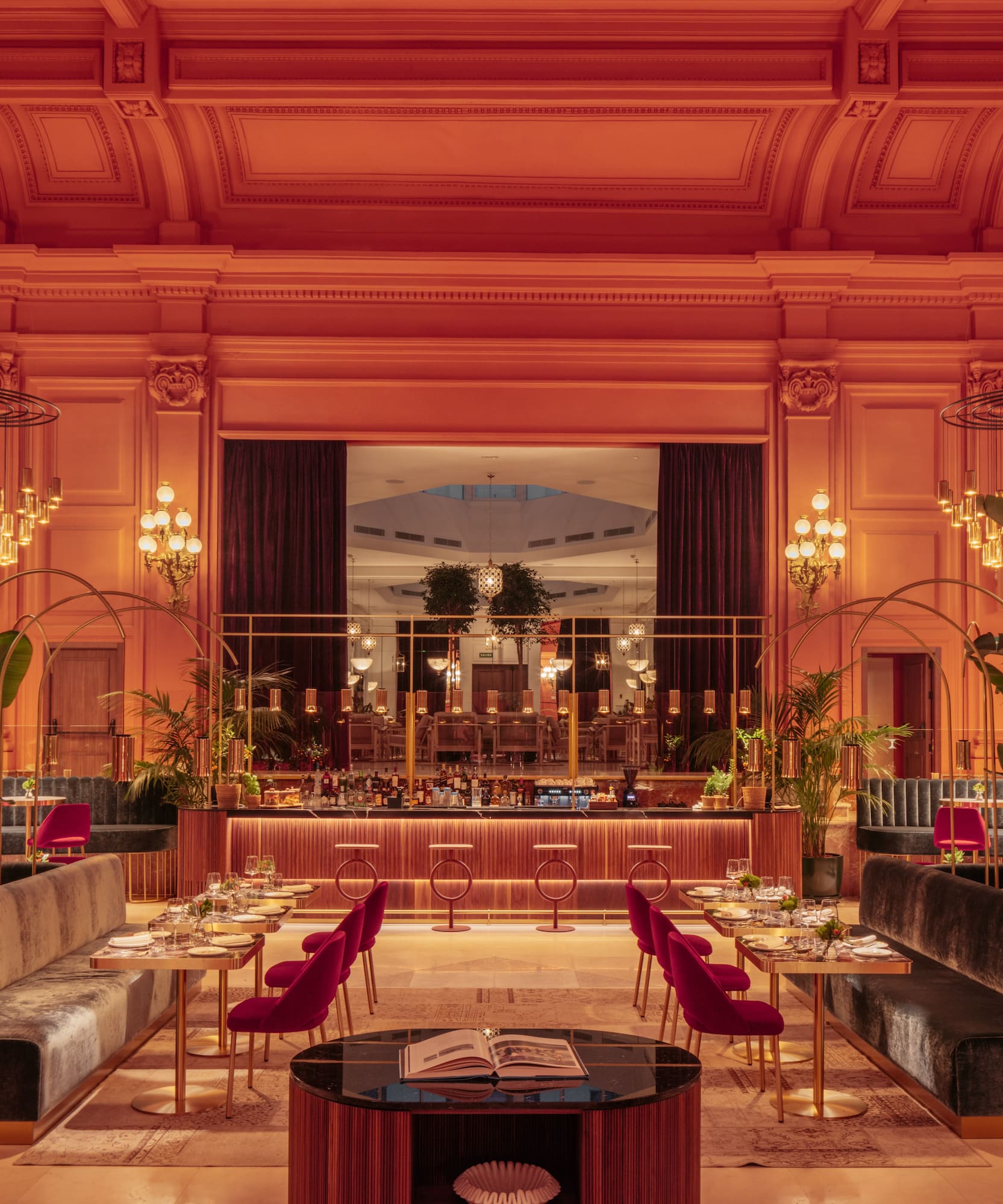a room with tables and chairs and chandeliers.