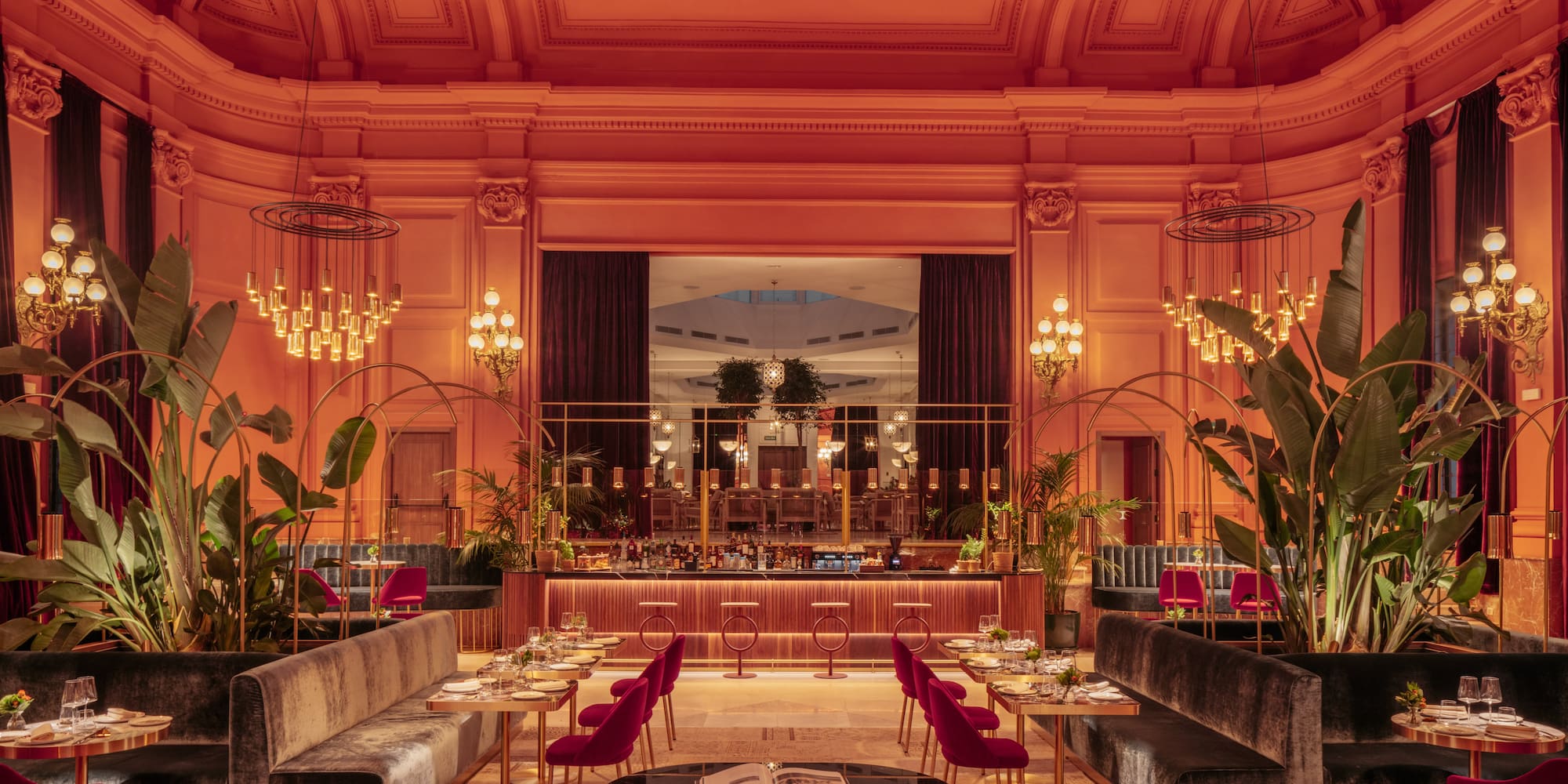 a room with tables and chairs and chandeliers