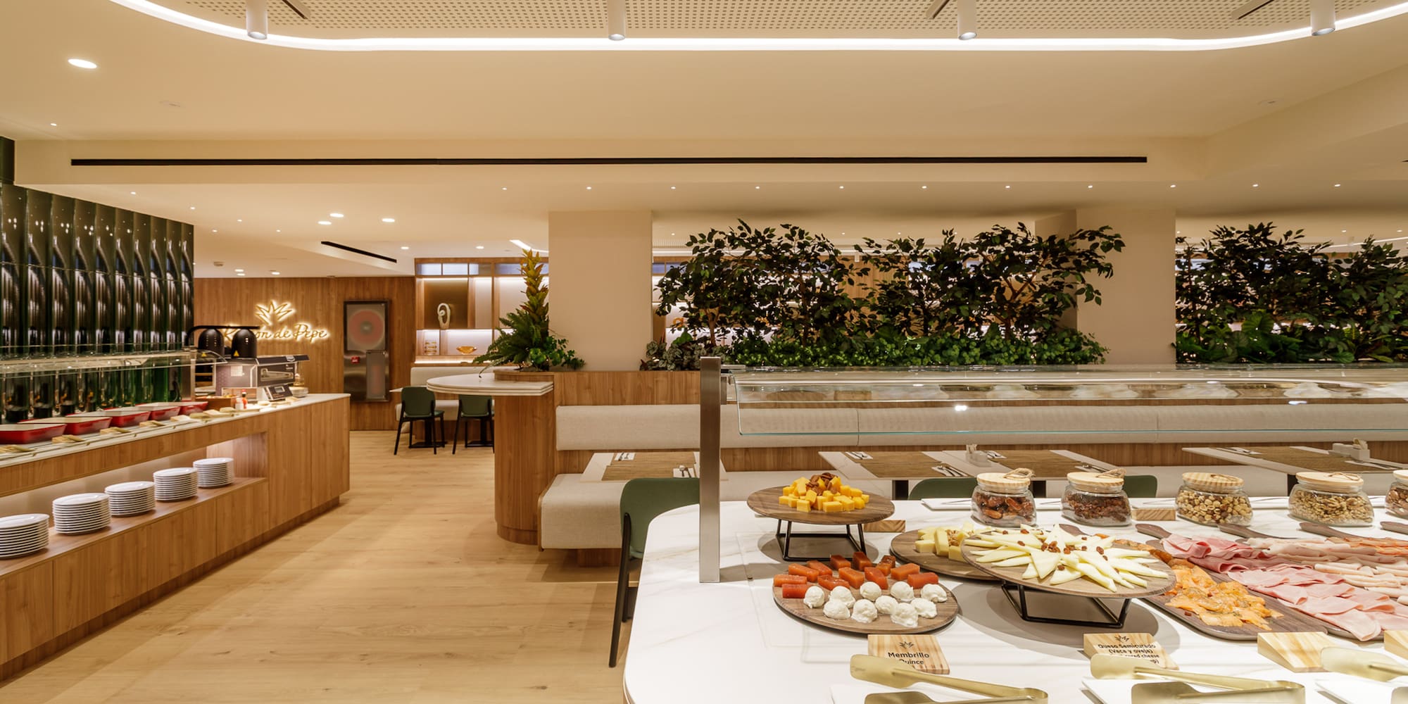 Modern hotel buffet featuring cheeses, meats, nuts, and hot dishes.